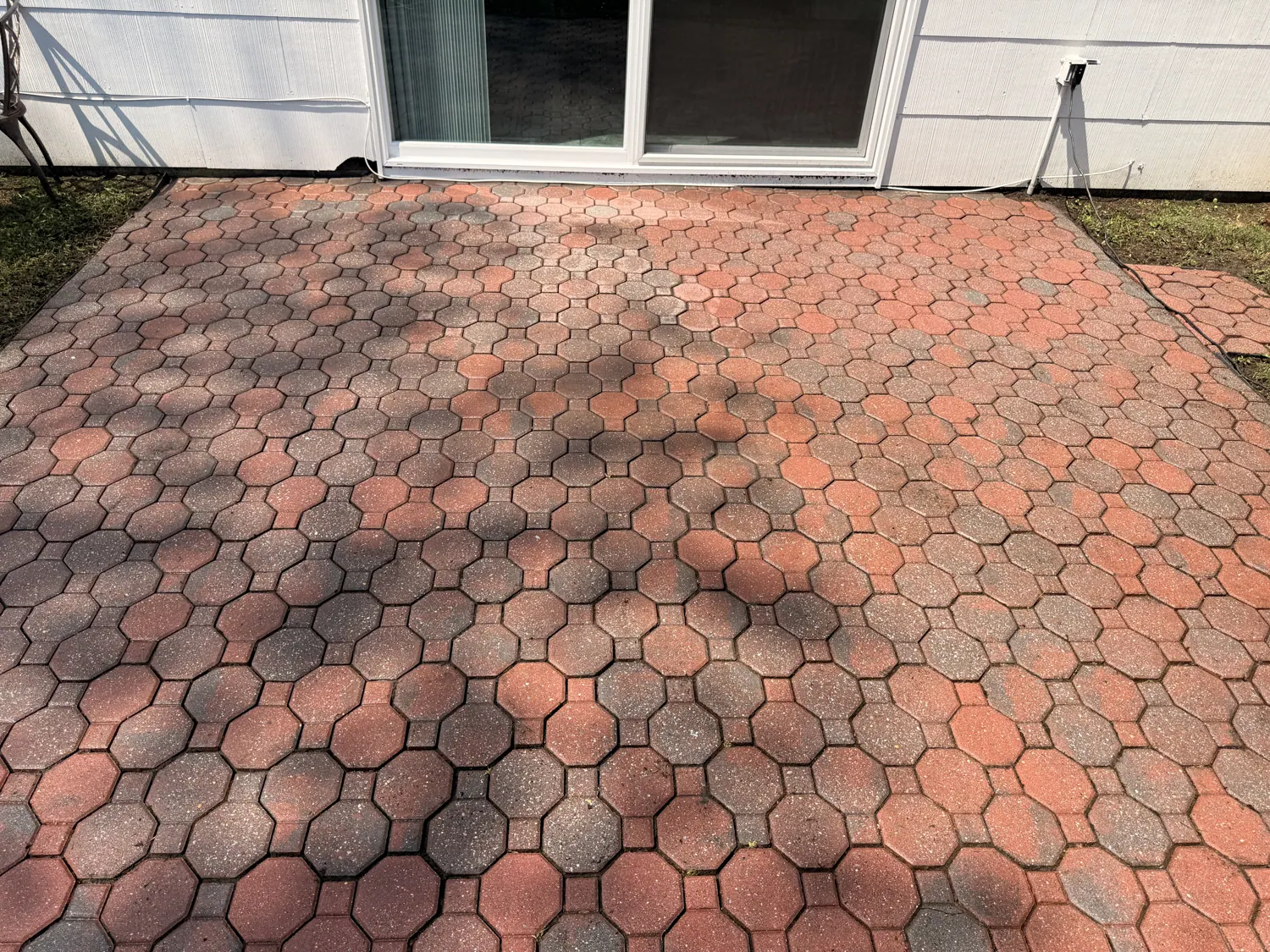 Red brick paver patio behind a house